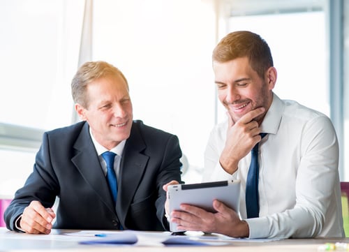 two-businessman-discussing-using-digital-tablet